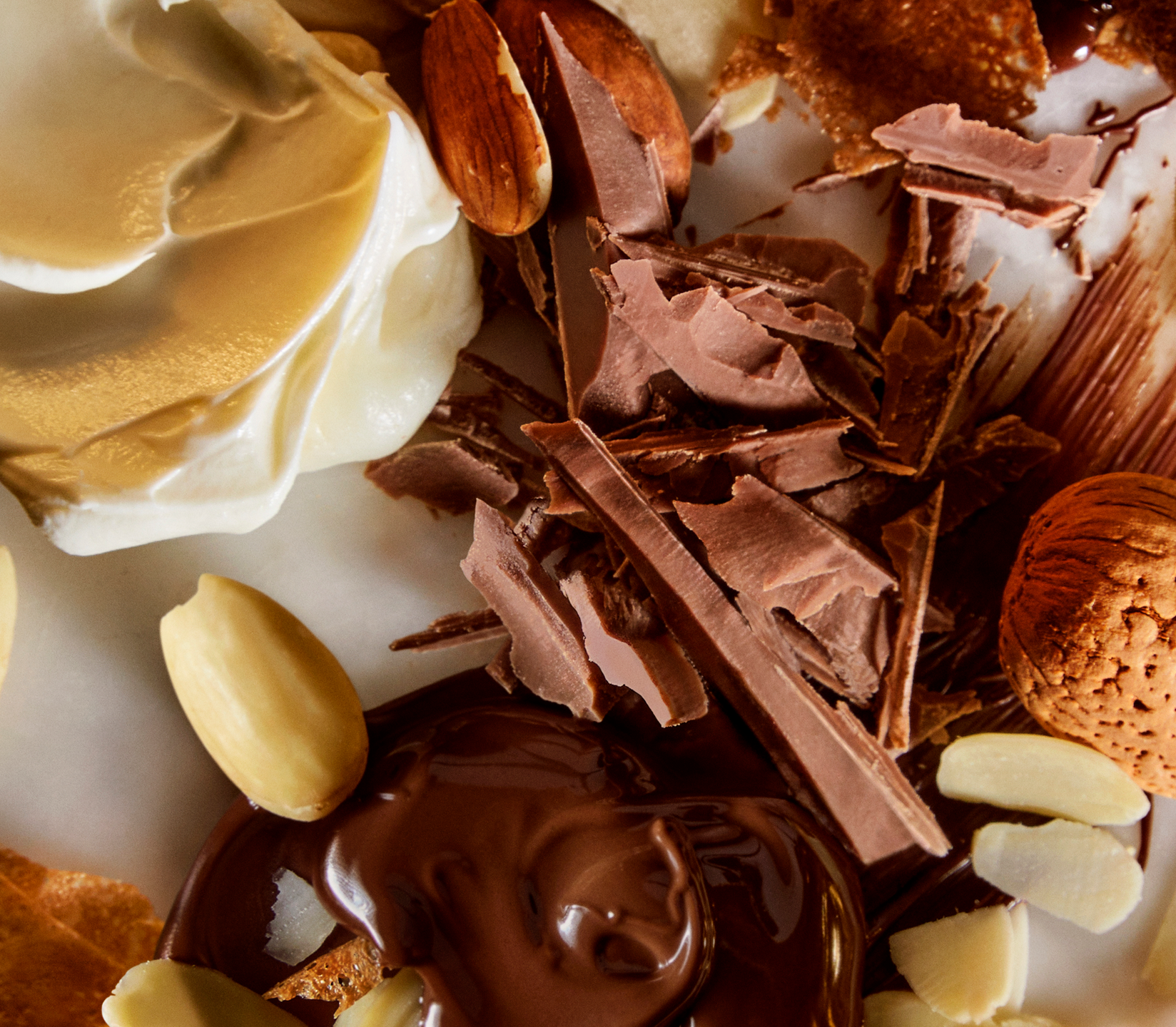 Close-up of chocolate, nuts, and cream on a white plate