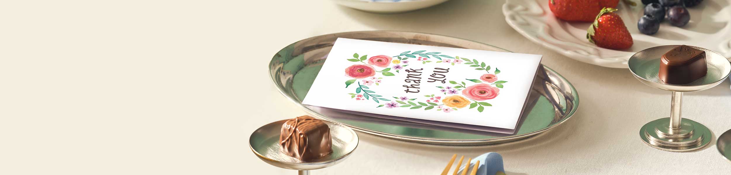 Greeting card with floral design on a table with desserts